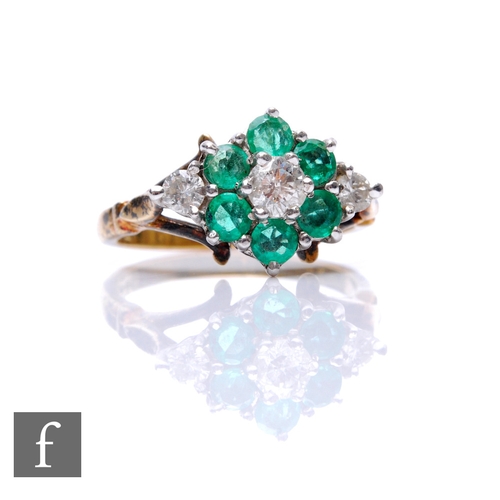 68 - An 18ct hallmarked emerald and diamond cluster ring, central diamond within a border of six emeralds... 