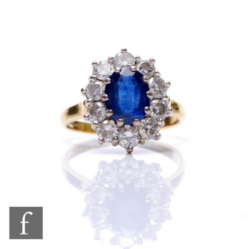 75 - An 18ct hallmarked sapphire and diamond cluster ring, central oval sapphire, length 9mm, within a bo... 