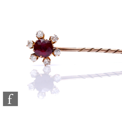 93 - An early 20th Century ruby and diamond set stick pin, central ruby, length 10mm, within a border of ... 