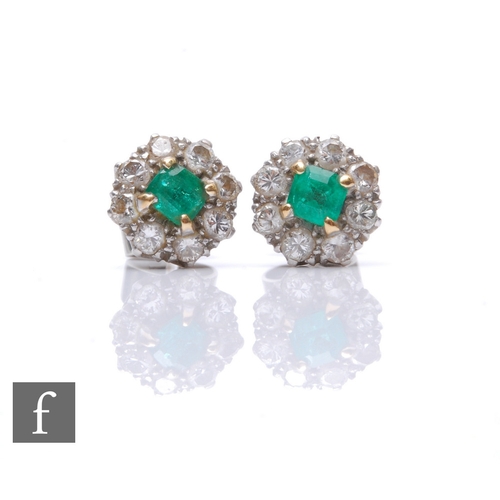 94 - A pair of 18ct white gold emerald and diamond cluster stud earrings each with a central square cut e... 