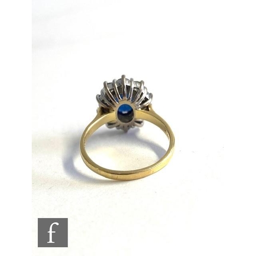 75 - An 18ct hallmarked sapphire and diamond cluster ring, central oval sapphire, length 9mm, within a bo... 