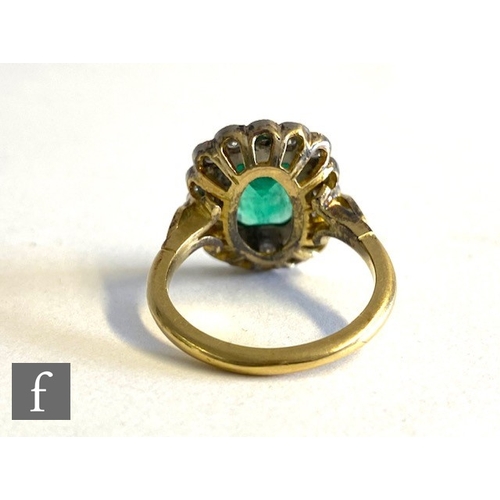 64 - An 18ct hallmarked emerald and diamond cluster ring, emerald cut emerald, length 9mm, collar set wit... 