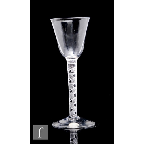 99 - An 18th Century drinking glass circa 1765, the round funnel bowl above a mixed twist stem with a sin... 