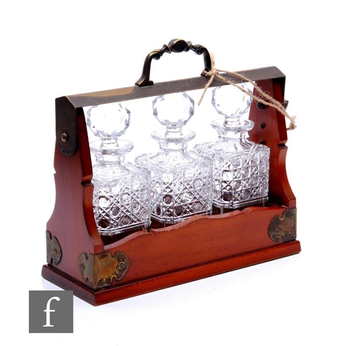 712 - A 20th Century mahogany cased tantalus, the frame decorated with applied plated brackets and plated ... 