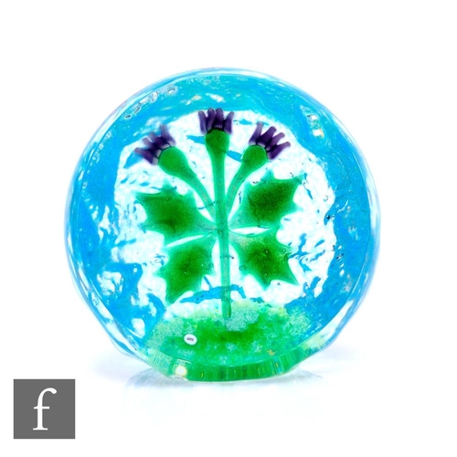 389 - A contemporary William Manson glass paperweight, internally decorated with a stylised thistle with g... 