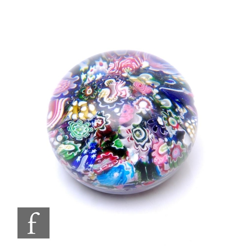 A Clichy glass paperweight of domed form, internally decorated with a scramble ground of multicoloured millefiori canes, cased in clear crystal, diameter 5cm.
