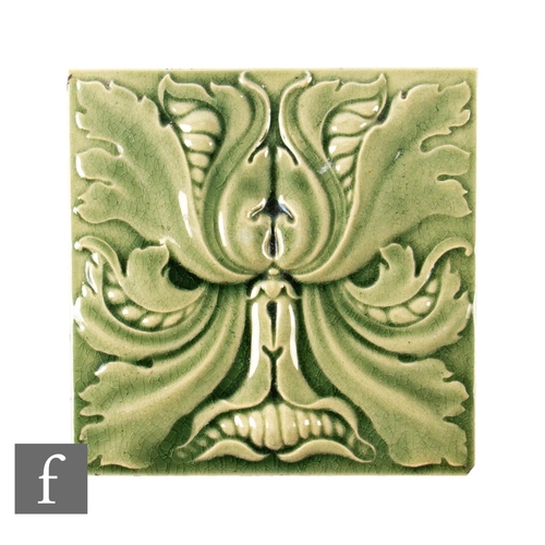 821 - An Arts and Crafts 6 inch tile decorated in relief with a green man style face formed of leaves, gla... 