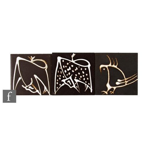 682 - Two 20th Century Carter 4 inch dust pressed black clay tiles, with slip trailed decoration of a styl... 