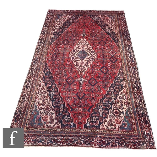 721 - A Turkish Hamedan wool rug, with central diamond lozenge and further purple and blue geometric desig... 