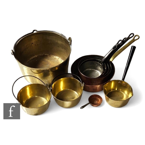 257 - A set of four iron strap handled saucepans, a similar copper and brass example, diameter 53cm, a bra... 