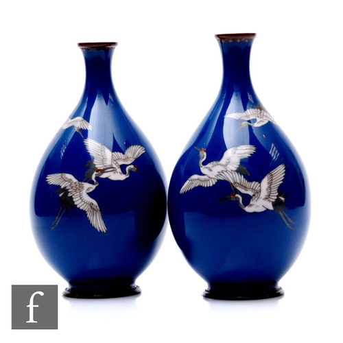 28 - A pair of early 20th Century Japanese cloisonne vases, each of bottle form, the blue ground of each ... 