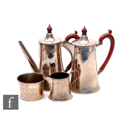 7 - A silver four-piece tea service, to include teapot, coffee pot, milk jug, sugar with hammered design... 