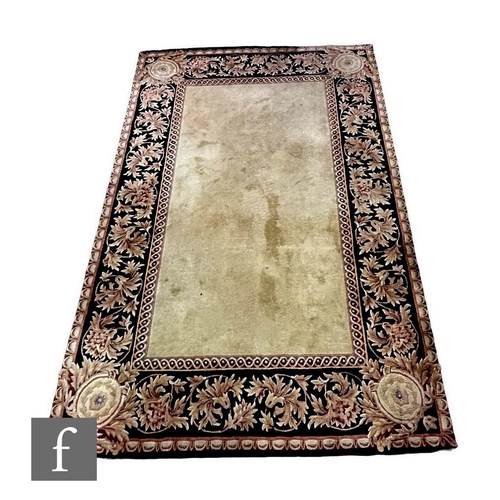 719 - A modern Chinese rug, the central beige panel within a floral border on a black ground, 271cm x 185c... 