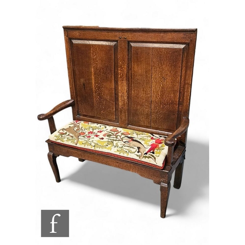 818 - A small 18th Century and later converted high back panelled oak settle, down swept arms, on cabriole... 