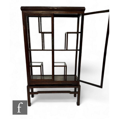 871 - A 20th Century mahogany glazed display cabinet in the Chinese style, fitted with internal stands, on... 