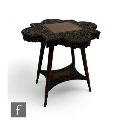 876 - A late 19th to early 20th Century carved hardwood occasional table, the shaped top richly detailed, ... 