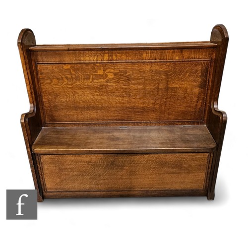 823 - An early 20th Century small oak pew, with shaped back a lozenge carved sides over a lift seat, heigh... 