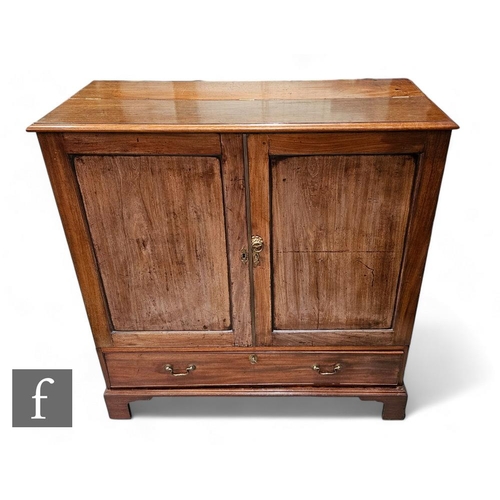 807 - A 19th Century mahogany cupboard enclosed by a pair of recessed moulded edge doors below a part hing... 