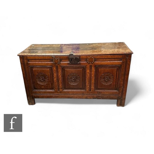 811 - An 18th Century oak coffer, the triple front with later carved roundel panels on stiles below a moul... 