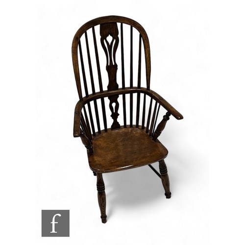 855 - A 19th Century ash and elm Windsor elbow chair, pieced vase splat, shaped seat on splayed turned leg... 