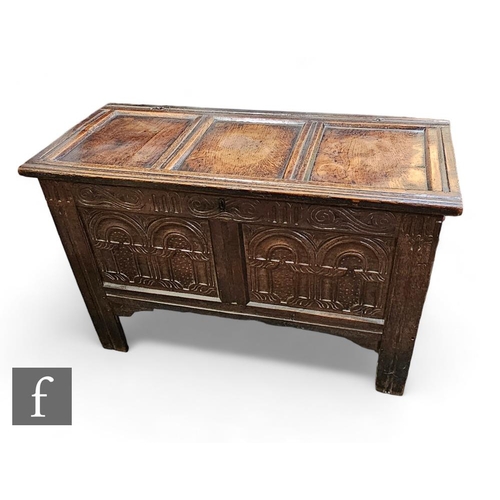 878 - An 18th Century triple panel coffer, the front carved with twin arch panels below a double scroll fr... 