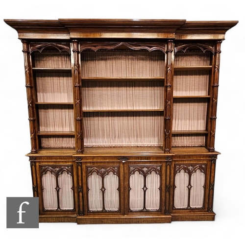 776 - A Victorian Gothic Revival Puginistic mahogany breakfront bookcase, the fluted moulded edge cornice ... 