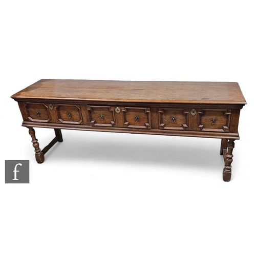 780 - A 17th Century style oak dresser base, the three drawer inverted moulded front below a plank top on ... 