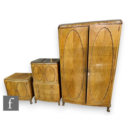 800 - A 1930s French Art Deco style walnut bedroom suite comprising a fitted wardrobe with three drawers a... 