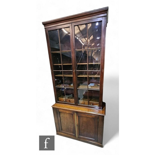 816 - A 19th Century mahogany bookcase enclosed by a pair of bar glazed doors, over a cupboard base, heigh... 