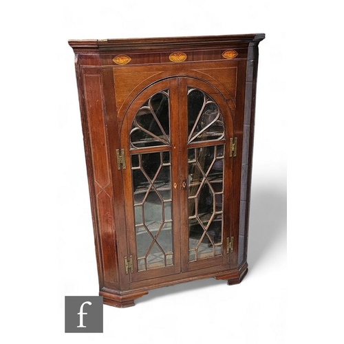 890 - A George III mahogany floorstanding corner cupboard, the shelf interior enclosed by a pair of astrag... 