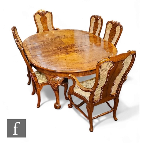 777 - A 20th Century Queen Anne style oval figured walnut extending dining table, the figured feather band... 