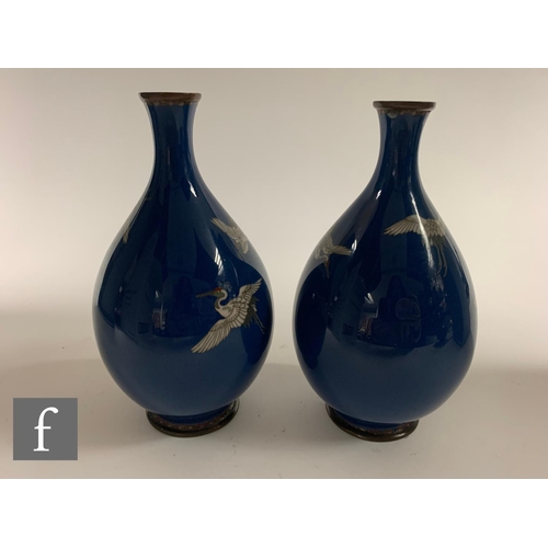 28 - A pair of early 20th Century Japanese cloisonne vases, each of bottle form, the blue ground of each ... 