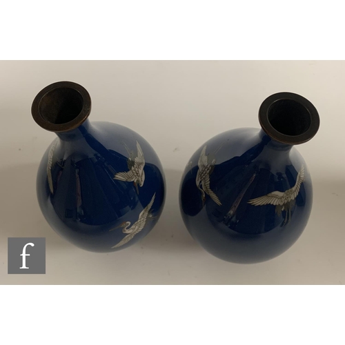 28 - A pair of early 20th Century Japanese cloisonne vases, each of bottle form, the blue ground of each ... 