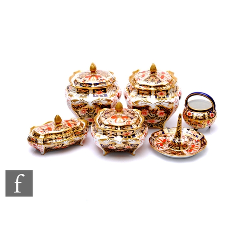 63 - A Royal Crown Derby Imari pattern part dressing table set, to include two bombe from jars and covers... 