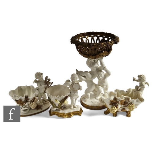 73 - A Moore Brothers figural centrepiece, modelled as three putti holding aloft a gilt metal reticulated... 