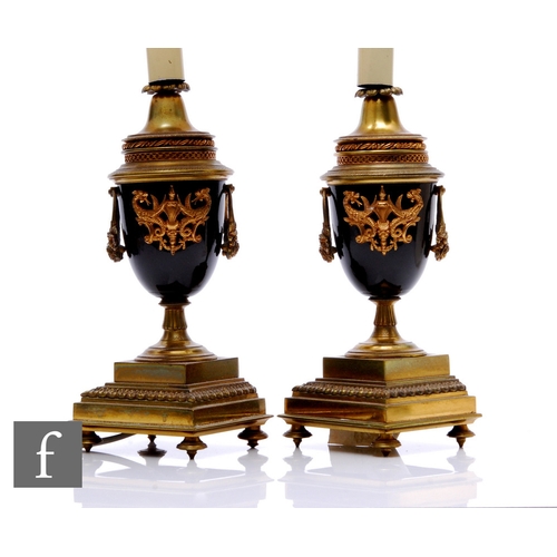 517 - A pair of French Empire style brass table lamps in the form of urns, gilt metal mounts, with shades,... 