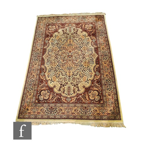 633 - A Kashmir style rug, central floral medallion within a rectangular border and multi border on a beig... 