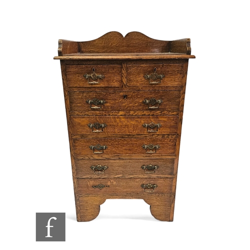 639 - A small Edwardian light oak office style chest of two short and five long drawers, brass aesthetic d... 