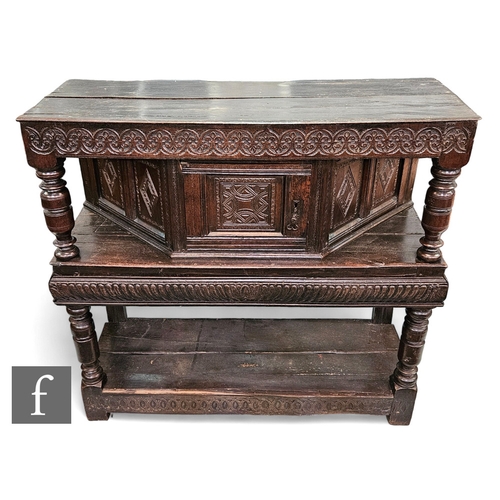 665 - A 17th Century and later constructed two tier oak buffet, the moulded edge plank top above an angled... 