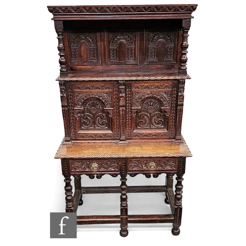 670 - A 17th Century style carved oak dresser, the super structure with triple arch panel back below a flu... 