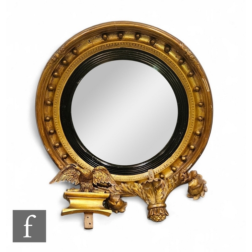 684 - A 20th Century Regency style circular gilt wall mirror, internal ebonised and ball detail, surmounte... 