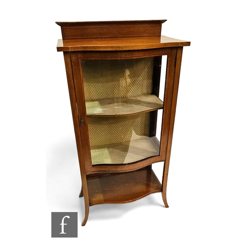 700 - An Edwardian inlaid mahogany serpentine fronted glazed display cabinet on splayed legs united by an ... 