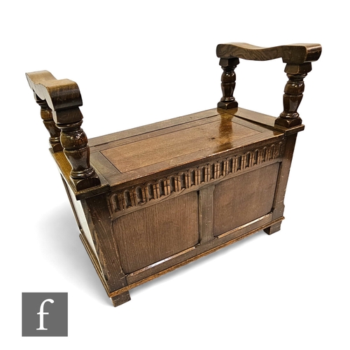 720 - A 1930s oak monks bench, the fold over top over a panelled front below a lunette frieze, height 77cm... 