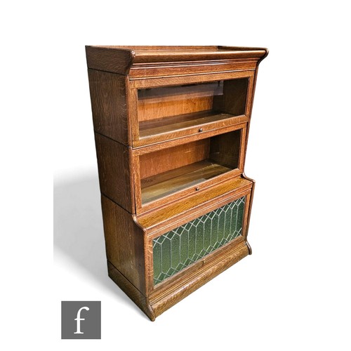 642 - A 1920s oak sectional three tier oak bookcase, stepped shape front on a plinth base, height 129cm x ... 