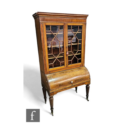 699 - A 19th Century mahogany cylinder bookcase enclosed by a pair of astragal glazed doors below a moulde... 