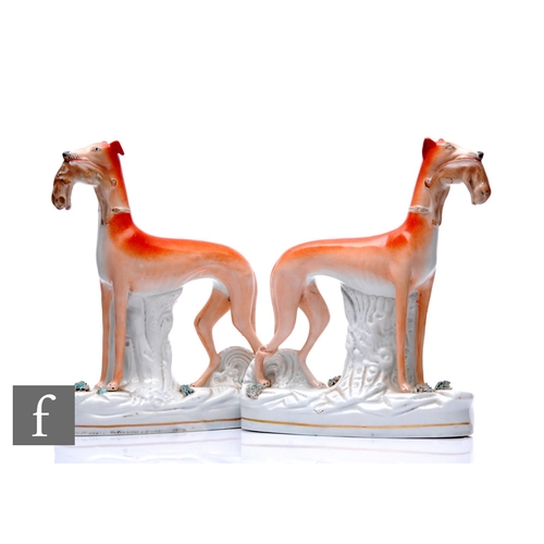 96 - A pair of mid 19th Century Staffordshire hunting dogs and hares, each on tree stump oval bases with ... 