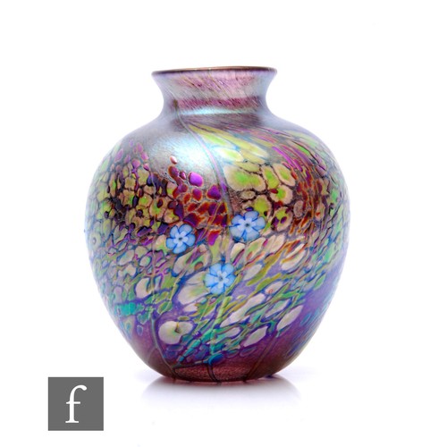 177 - An Okra glass vase of ovoid form decorated with stylised flowers and leaves over iridescent purple g... 