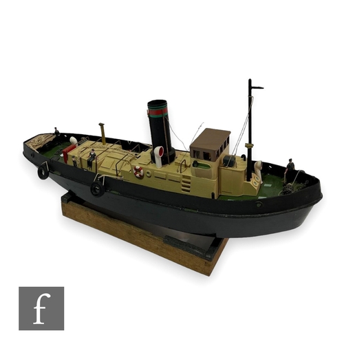 533 - A scale wooden model of a tug boat, painted black and green, with single funnel cream deck and figur... 