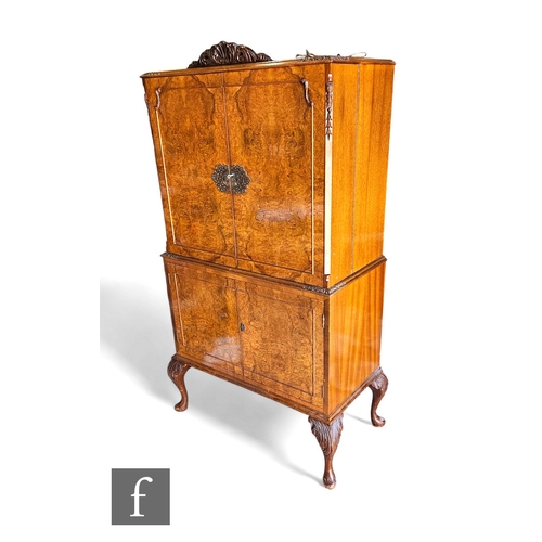 731 - A Queen Anne style walnut cocktail cabinet, fitted mirror interior enclosed by a pair of doors, on c... 