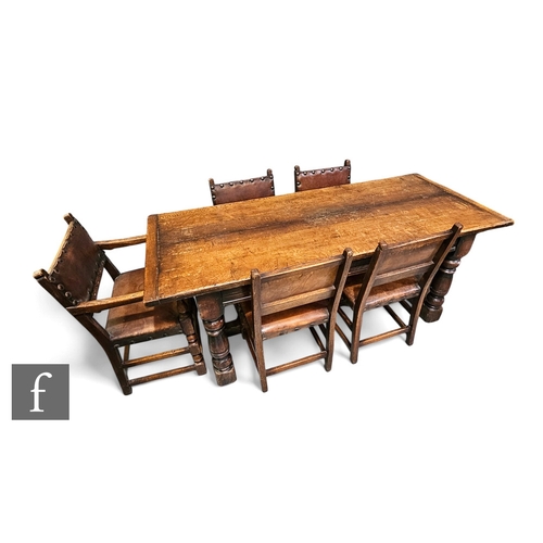 725 - A 17th Century style oak refectory dining table, the cleated end plank top over a moulded edge friez... 